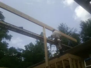 Carpenter setting a ridge beam over a new addition frame — Ice Dam Removal by Roofing Brothers in Willow Spring
