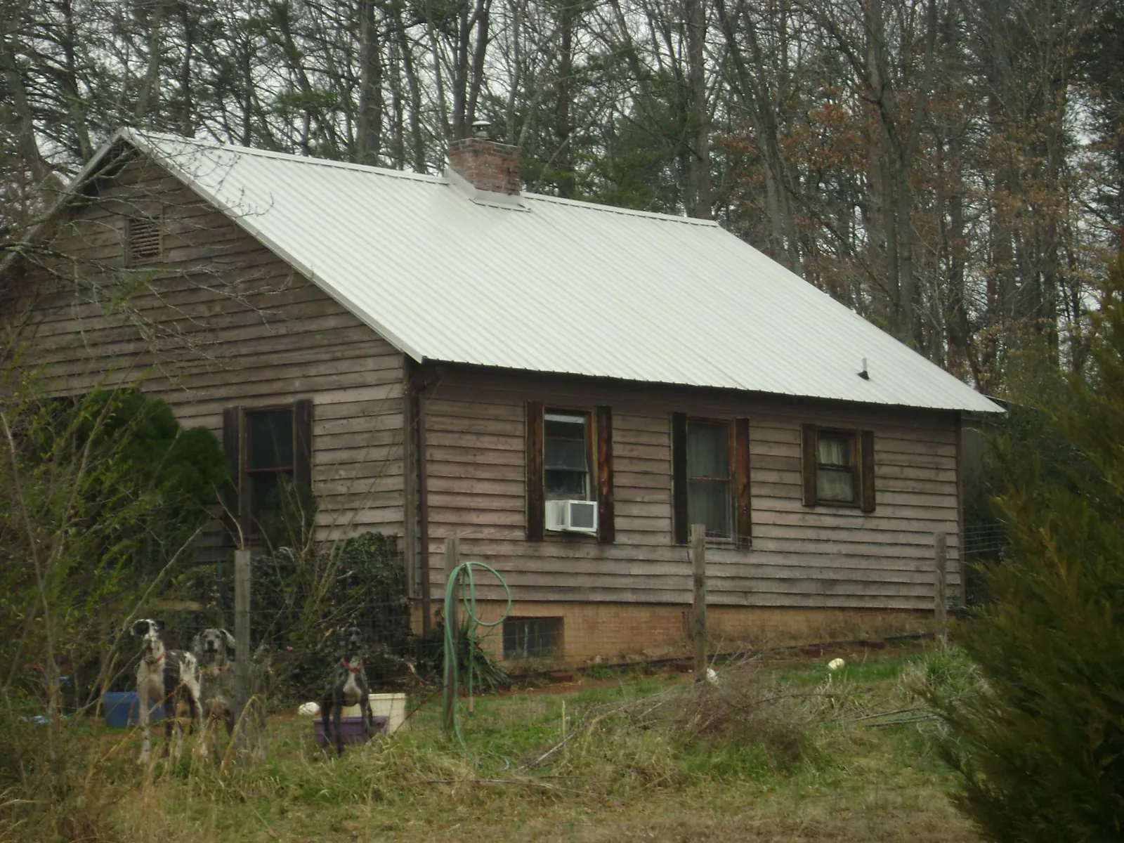 White metal roof on an old wood sided farmhouse, from a Metal Roof Installation job in Willow Spring
